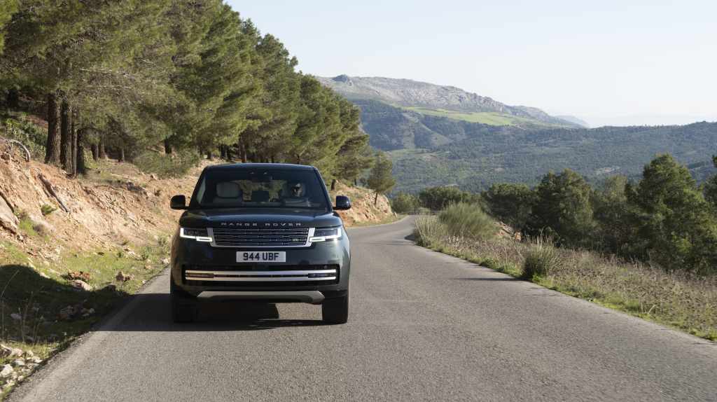 2027 Range Rover Electric driving on a mountain road at Land Rover Solon in Solon, OH